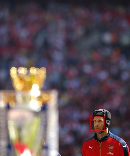 Arsenal football player standing looking at trophy